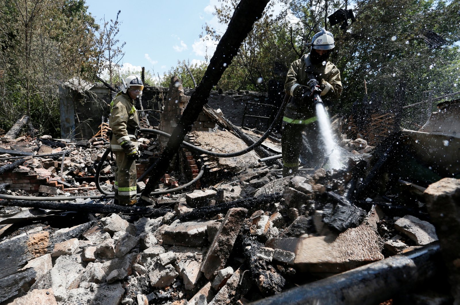 Firefighters work at the ruins of a house, which locals said was destroyed during a recent shelling, in the rebel-controlled city of Donetsk, Ukraine, July 22, 2020. (Reuters Photo)