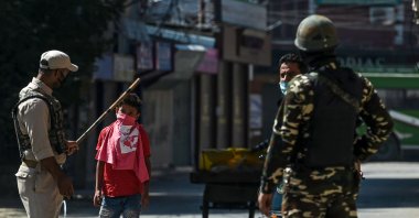 Security personnel stop pedestrians on a street during a lockdown imposed by the authorities as a preventive measure against the surge in COVID-19 coronavirus cases, in Srinagar, July 23, 2020. (AFP Photo)