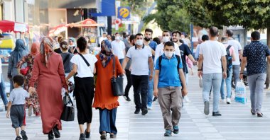 People wearing masks against COVID-19 walk on a street in Şanlıurfa, southeastern Turkey, July 24, 2020. (DHA Photo)