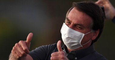 In this file picture taken on July 20, 2020 Brazilian President Jair Bolsonaro gives the thumbs up to supporters from the Alvorada Palace in Brasilia, amid the new coronavirus pandemic.(AFP Photo)