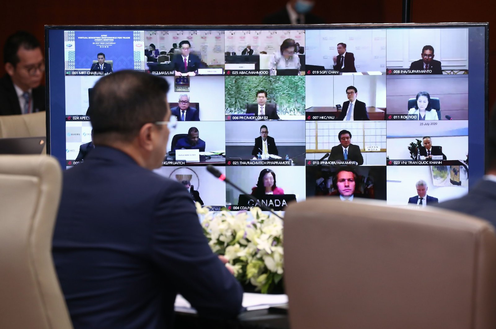 Mohamed Azmin Ali (L), Malaysia's Minister of International Trade and Industry, speaking before a monitor showing participants in the 2020 APEC Virtual Ministers Responsible for Trade Meeting on the COVID-19 coronavirus crisis in Kuala Lumpur, Malaysia on July 25, 2020. (AFP Photo)