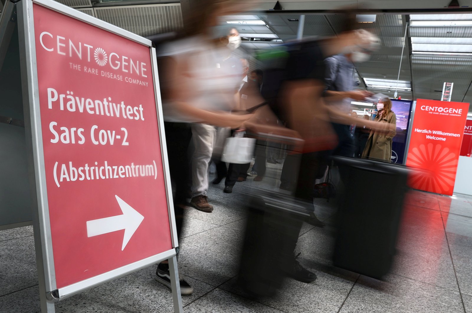 Travelers rush past the entry of Germany's first walk-through coronavirus disease (COVID-19) test center which is opened by diagnostics provider Centogene in cooperation with air carrier Lufthansa and Fraport at the airport in Frankfurt, Germany on June 29, 2020. (Reuters Photo)