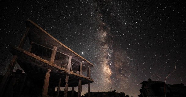 This long-exposure picture shows a view of the Milky Way galaxy rising in the sky above destroyed buildings in the village of Balyun in the opposition-held southern countryside of Syria's northwestern province of Idlib, near the frontline with government forces, July 21, 2020. (AFP Photo)