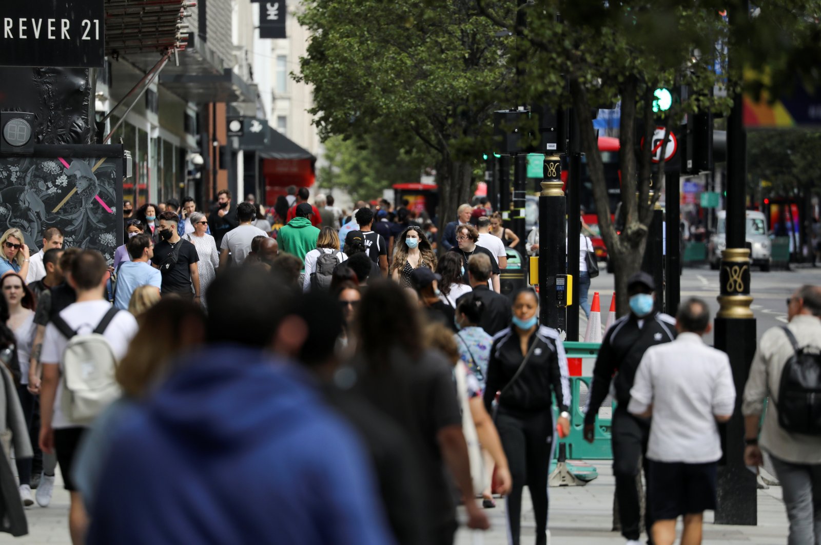 People, some of them wearing protective masks, walk down Oxford Street as the spread of the coronavirus disease (COVID-19) continues, in London, Britain July 24, 2020. (REUTERS Photo)
