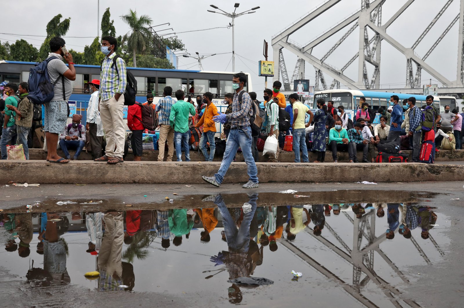 Migrant workers wait for transport outside the Howrah railway station after authorities announced a lockdown for two days every week in the West Bengal state, amid the spread of the coronavirus, in Kolkata, India, July 23, 2020. (Reuters Photo)