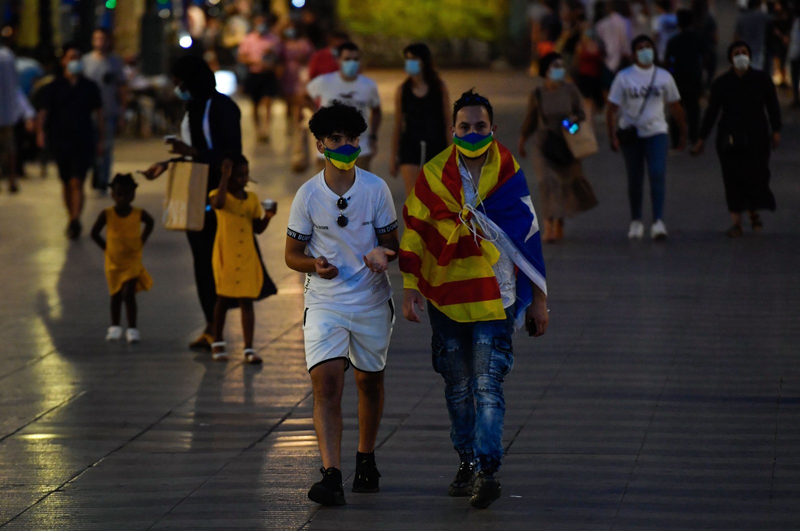 A man wrapped in a Catalan pro-independence "Estelada" flag walks on Las Ramblas street in Barcelona on July 25, 2020. (AFP Photo)
