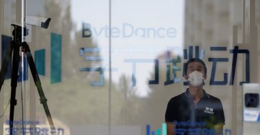 A security guard, wearing a face mask to protect against the coronavirus, stands near a surveillance camera at an office of Bytedance, the China-based company which owns the short video app TikTok, in Beijing, China, July 7, 2020. (Reuters Photo)