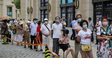 People line up to undergo COVID-19 tests at a makeshift testing center in Dalian, in China's northeast Liaoning province, July 27, 2020. (AFP Photo)