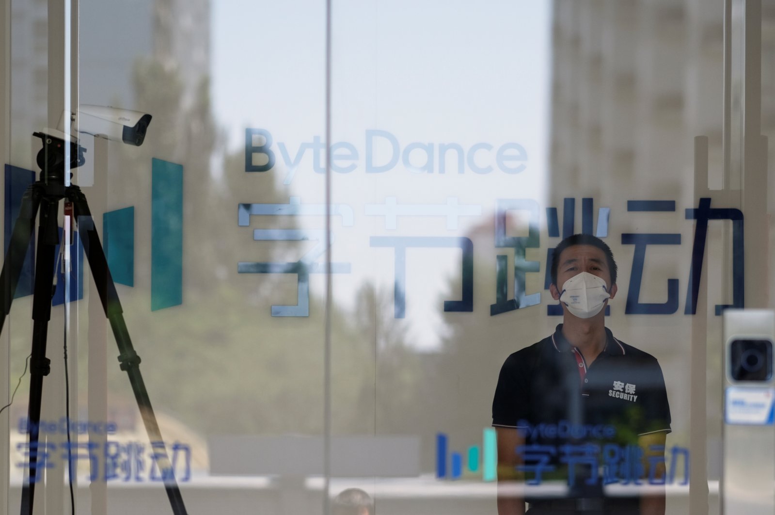 A security guard, wearing a face mask to protect against the coronavirus, stands near a surveillance camera at an office of Bytedance, the China-based company which owns the short video app TikTok, in Beijing, China, July 7, 2020. (Reuters Photo)