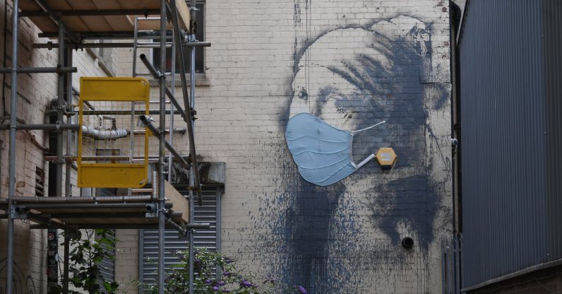 British artist Banksy's work 'Girl with a Pierced Eardrum' is displayed wearing a face covering in Bristol, UK, July 15, 2020. (EPA Photo)