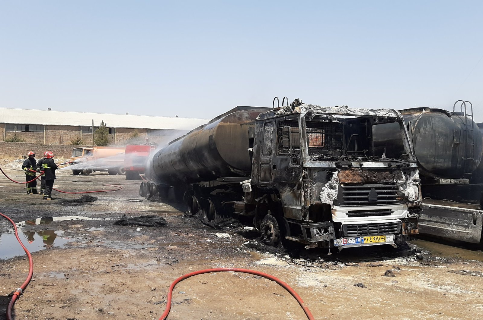 Firefighters put out the fire on fuel tanks after they were hit by an explosion in Kermanshah province, Iran July 28, 2020. (WANA Photo via Reuters) 