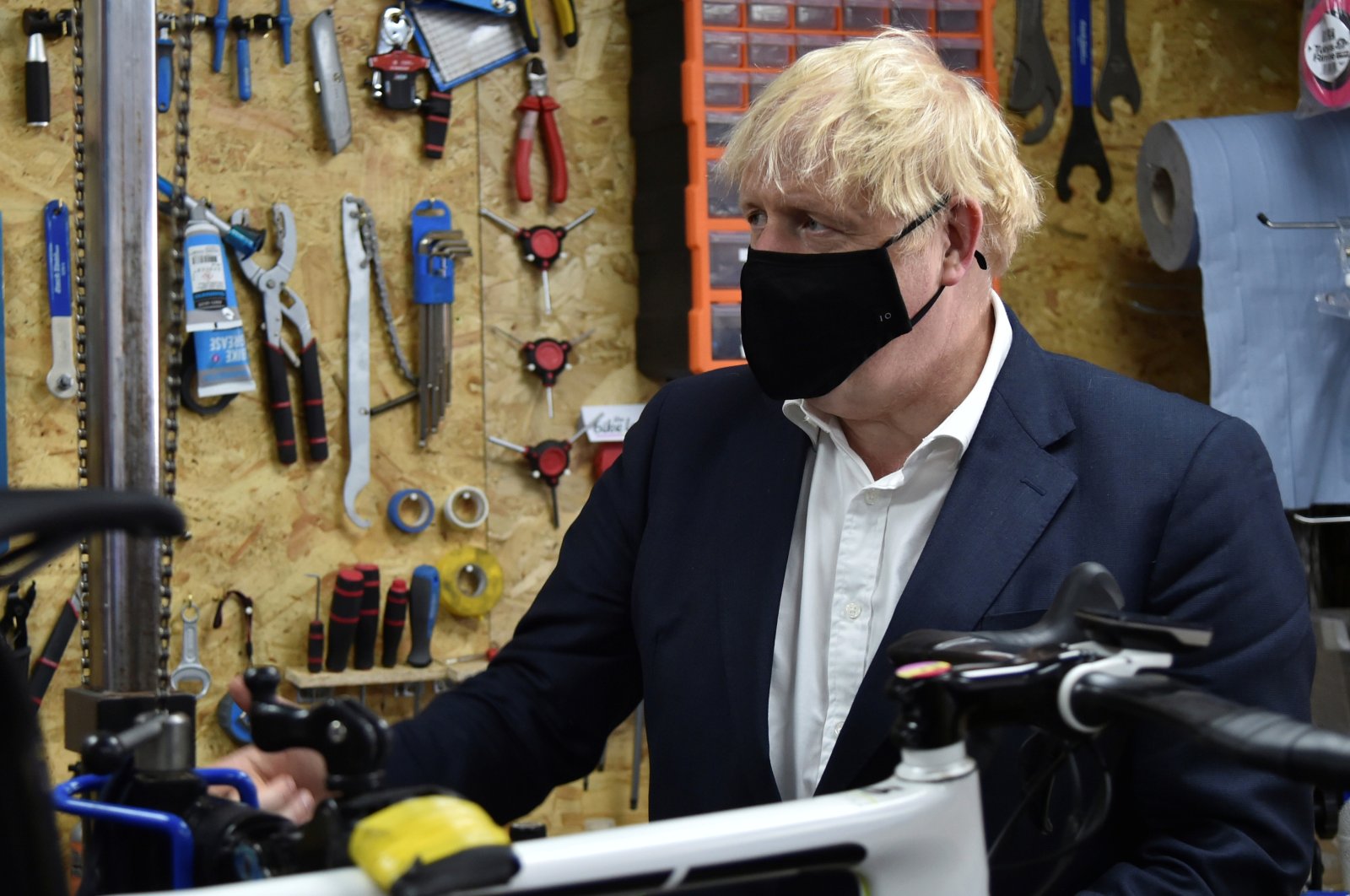 Britain's Prime Minister Boris Johnson talks to the owner of the the Cycle Lounge, Rodney Rouse, a bicycle repair shop, after the government announced a new plan to get Britain cycling, amid the outbreak of the coronavirus, in Beeston near Nottingham, Britain, July 28, 2020. (Reuters Photo)