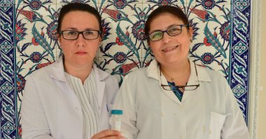Researchers Dilvin Ipek (L) and associate professor Nükhet Zorba pose with the disinfectant they created at Çanakkale Onsekiz Mart University, July 24, 2020. (AA Photo)