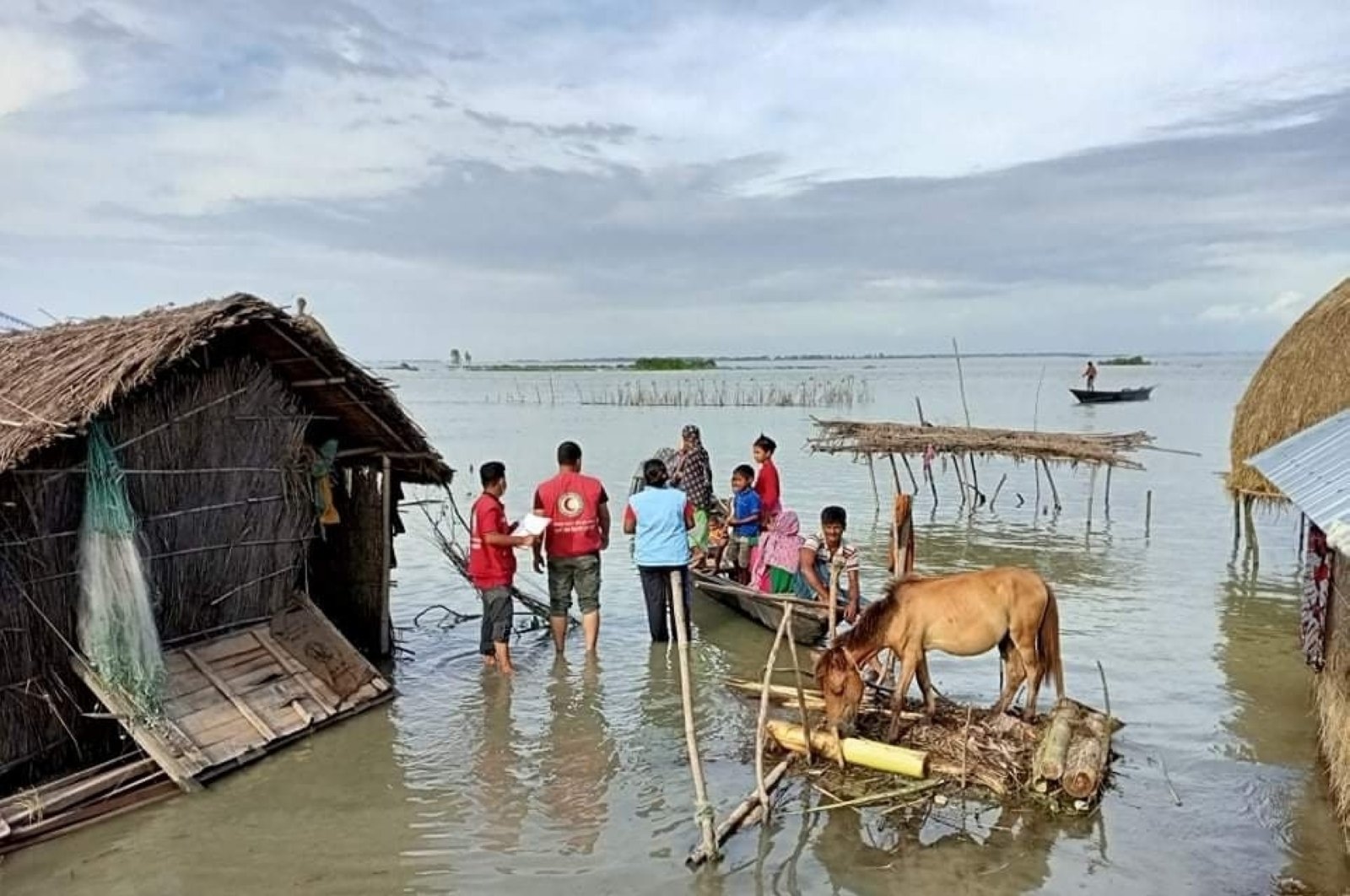 This photograph, provided by the International Federation of Red Cross and Red Crescent Societies (IFRC), shows IFRC volunteers reaching flood-affected communities with drinking water and other support in Kurigram, Bangladesh, July 16, 2020. (AP Photo)