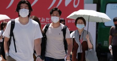 People wearing face masks walk across Shibuya Crossing in the Shibuya shopping and entertainment district in Tokyo, Japan, July 26, 2020. (AFP Photo)