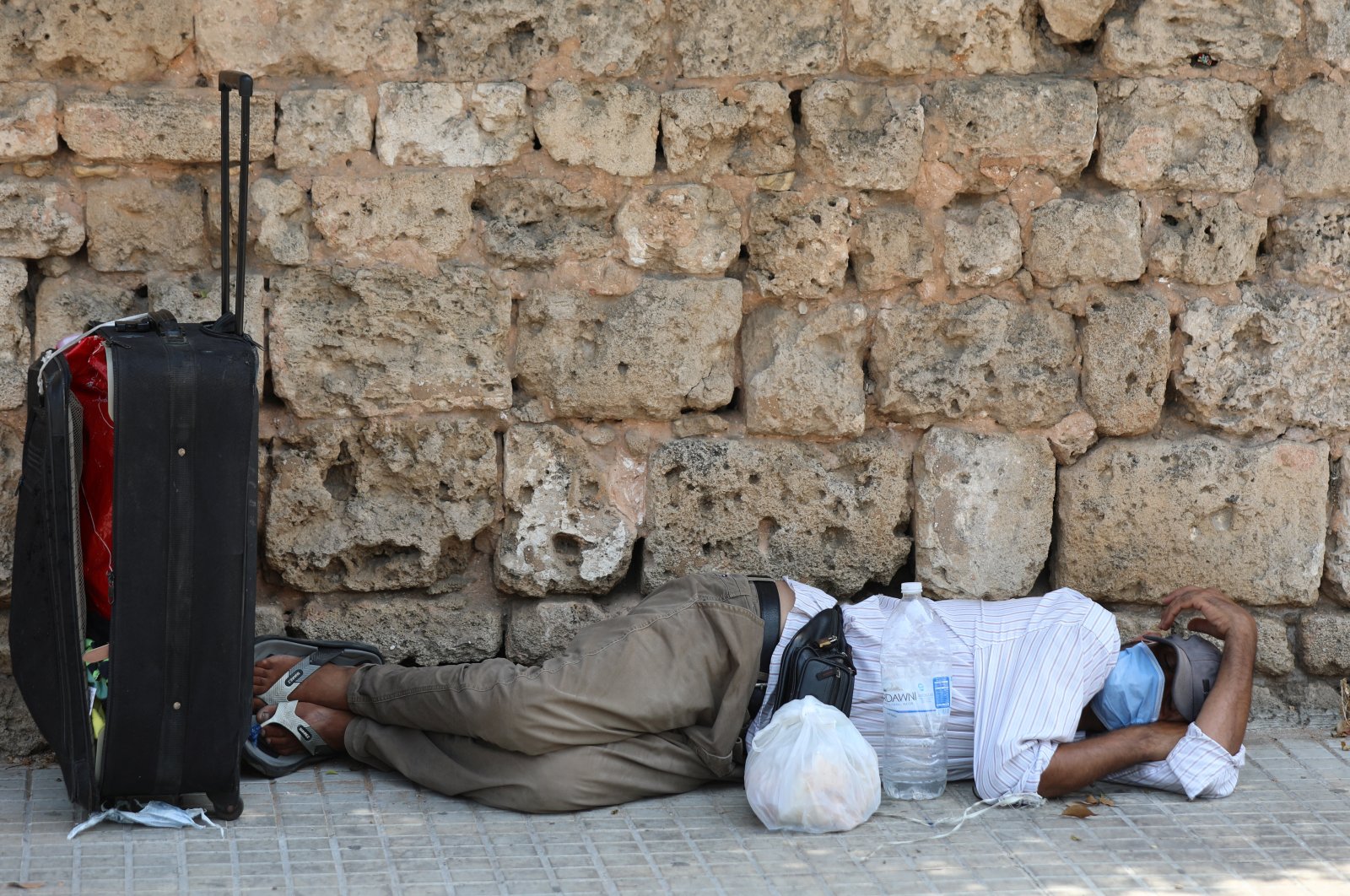 A man lies on the ground as he wears a face mask to prevent the spread of the coronavirus, Beirut, Lebanon, July 28, 2020. (REUTERS Photo)