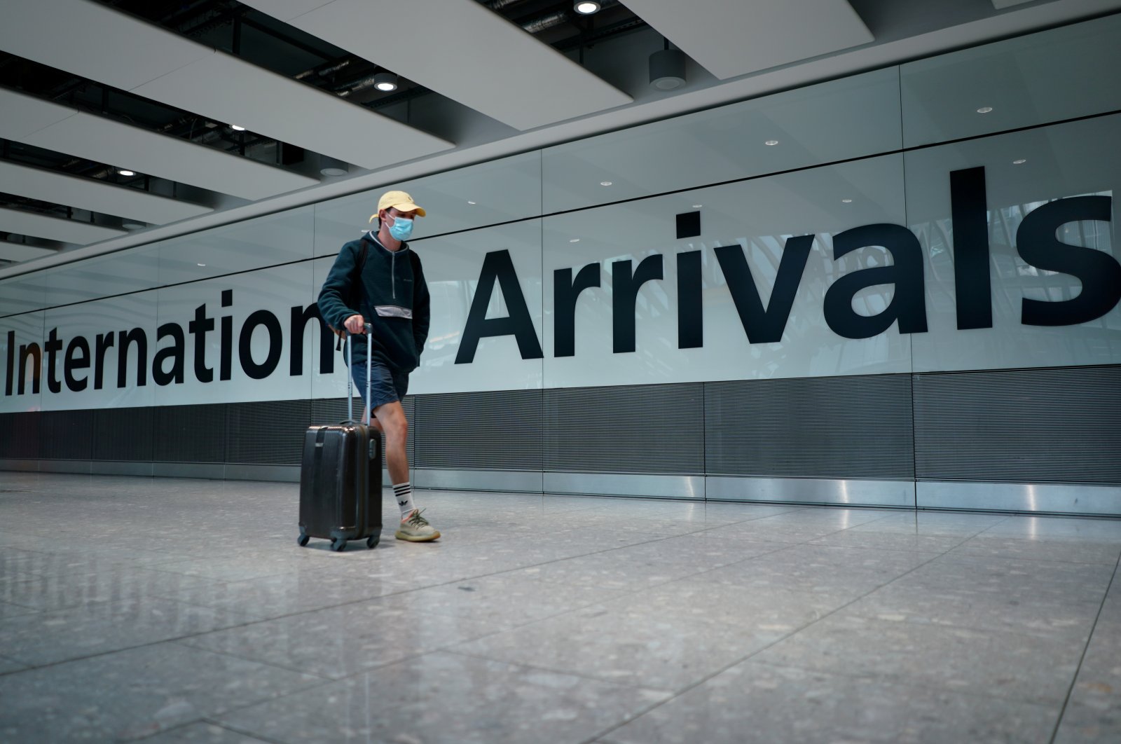 A traveler wearing a face mask walks in Terminal 5 at Heathrow Airport, as the spread of the coronavirus continues, in London, Britain, July 26, 2020. (Reuters Photo)