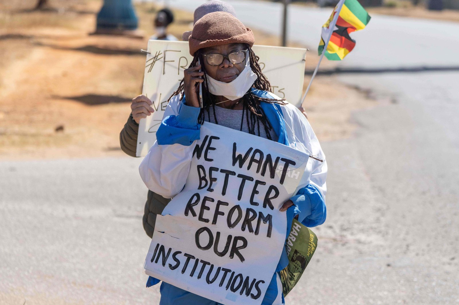 Zimbabwean novelist Tsitsi Dangarembga holds a placard during an anti-corruption protest march along Borrowdale road,  Harare, Zimbabwe, July 31, 2020. (Photo by ZINYANGE AUNTONY / AFP)
