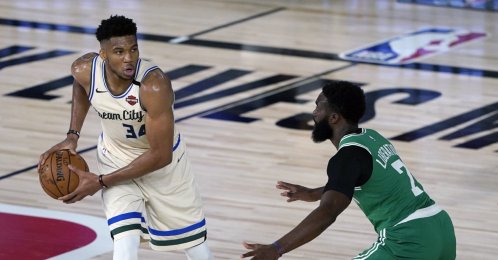 The Milwaukee Bucks' Giannis Antetokounmpo (L) looks to pass around the Boston Celtics' Jaylen Brown (R) during the first half of an NBA basketball game in Lake Buena Vista, Florida, July 31, 2020. (Ashley Landis/Pool Photo via USA Today Sports/Reuters)