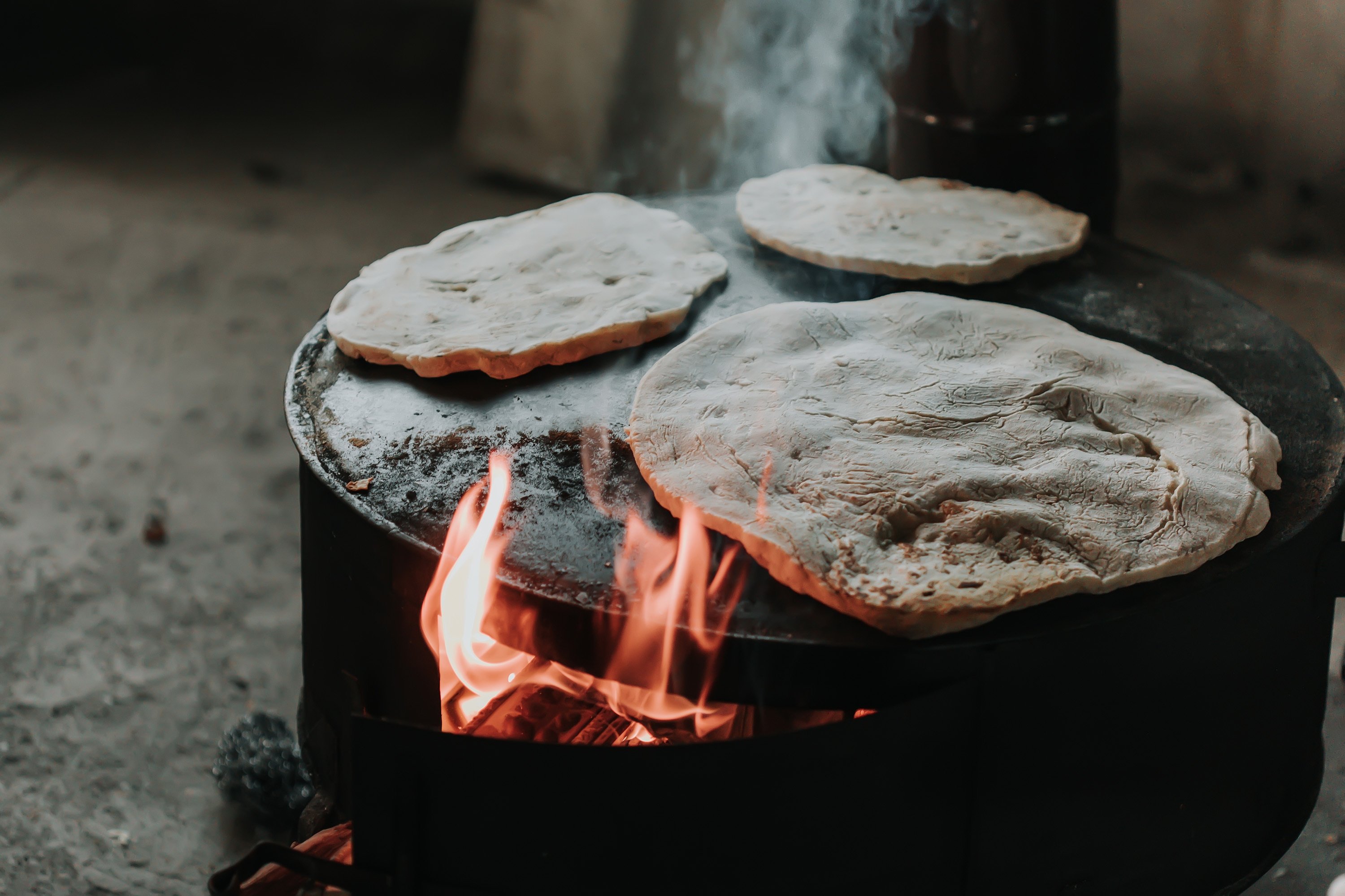 Breads such as lavaş or bazlama are cooked on shallow metal domes called "sac" over a roaring fire. (Shutterstock Photo)