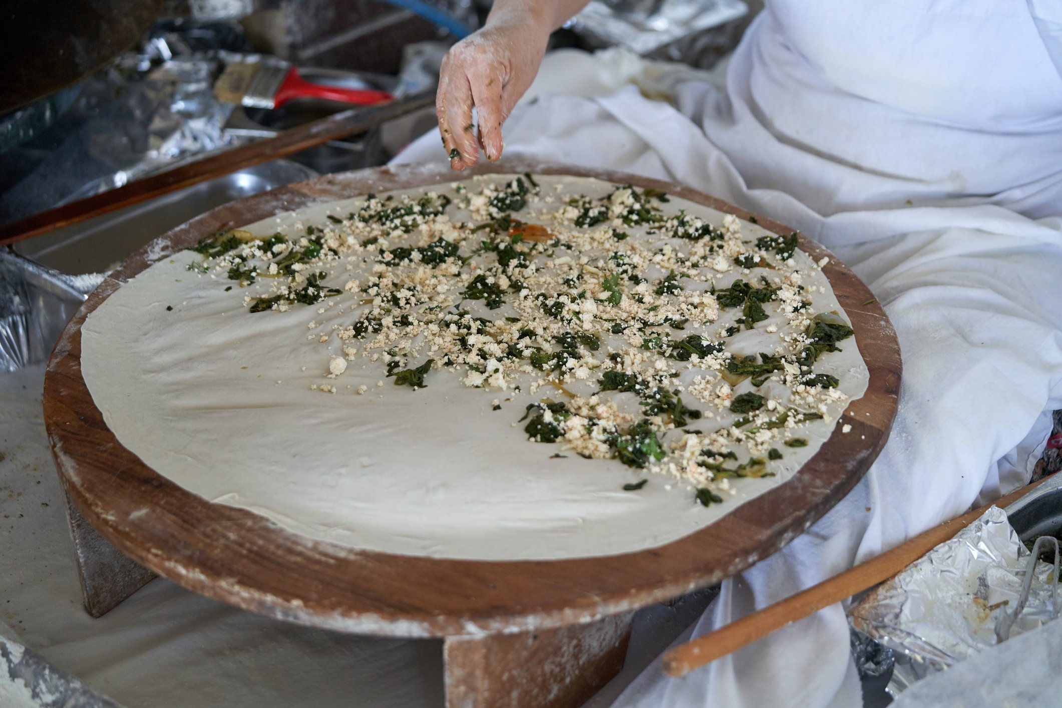 Filling her yufka sheets with cottage cheese and spinach, a woman makes a traditional Turkish gözleme.(iStock Photo)