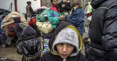 Roma people wait as bulldozers destroy their makeshift camp in Villeurbanne, near Lyon, Franc, March 28, 2013. (AFP Photo)