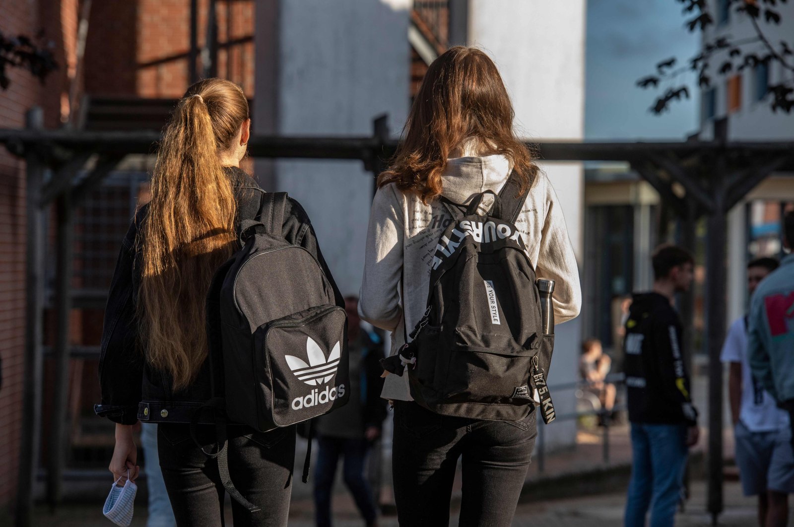 A student (L) carries a face mask as she heads into the Christophorusschule school in Rostock on Aug. 3, 2020. (AFP Photo)