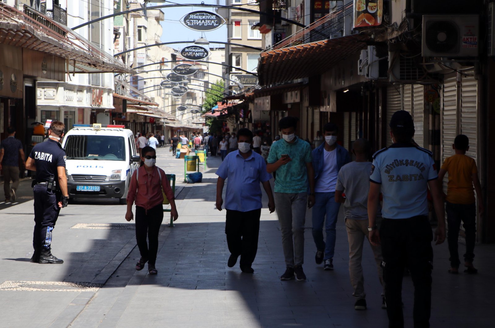 People wearing protective masks walk on a street in Gaziantep, southern Turkey, Aug. 2, 2020. (DHA Photo)