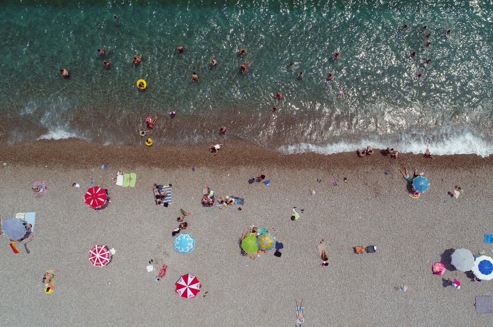 Holidaymakers enjoy the sun at Konyalatı beach in southern resort city Antalya, Turkey, Aug. 2, 2020. (DHA Photo)