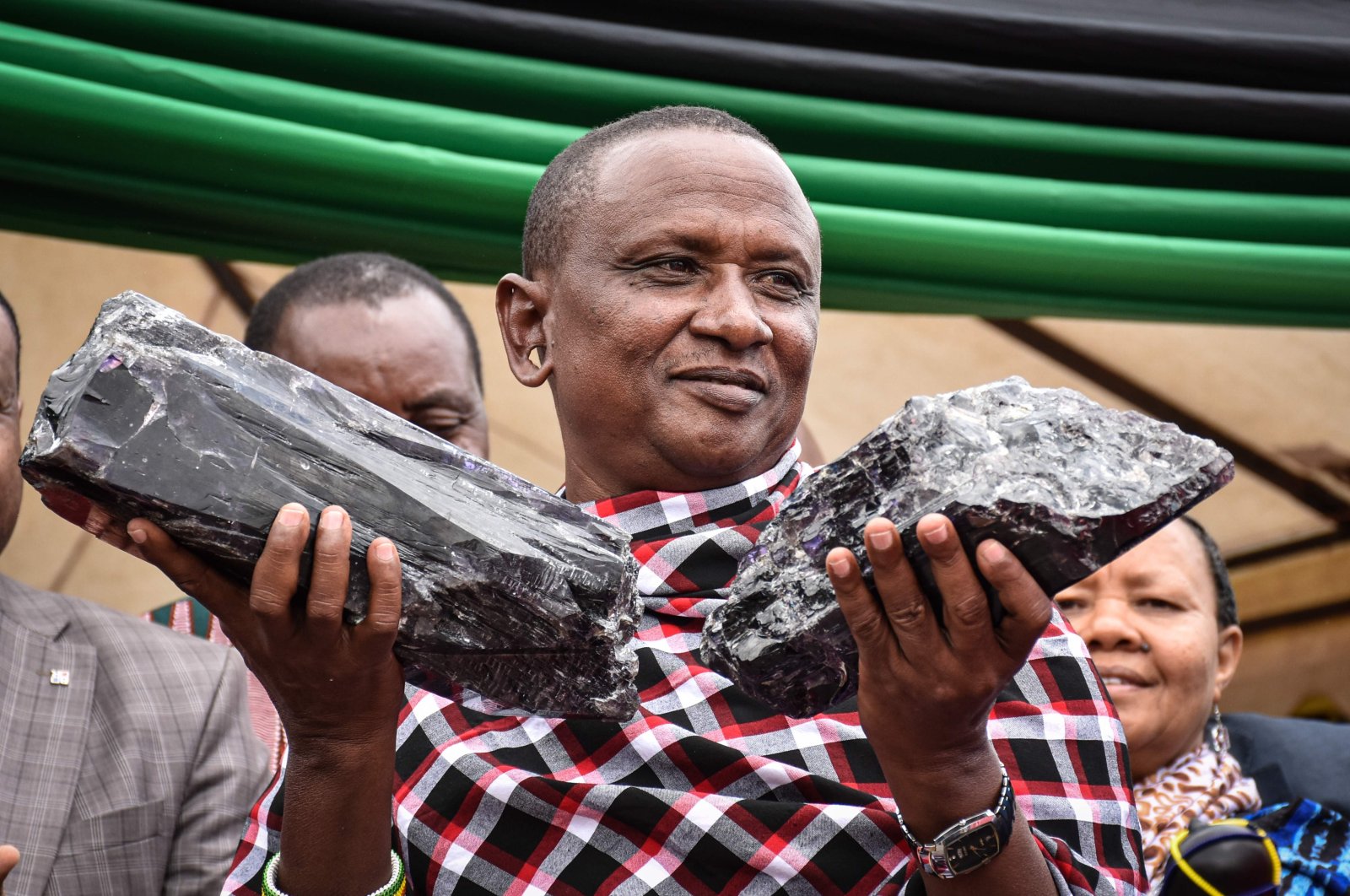 Tanzanian miner Saniniu Kuryan Laizer, 52, poses with two of the country's biggest precious gemstones, Tanzanite, during a handing-over ceremony in Manyara, northern Tanzania, June 24, 2020. (AFP Photo)