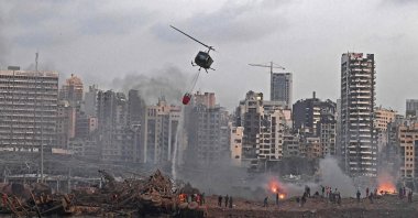 A helicopter is dispatched to put out multiple fires at the scene of the massive explosion that hit a port in Beirut, Lebanon, Aug. 4, 2020. (AFP Photo)