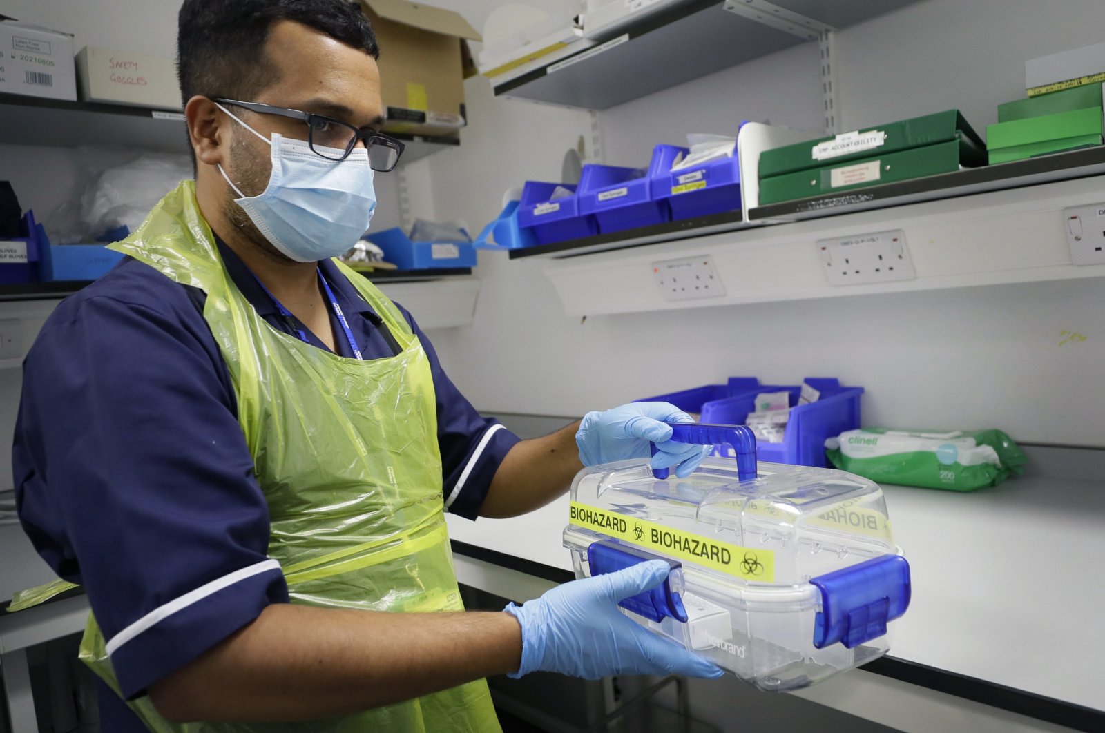 Senior Clinical Research Nurse Ajithkumar Sukumaran carries the vaccine as it is about to be prepared prior to being administered to a volunteer, at a clinic in London, Wednesday, Aug. 5, 2020. (AP Photo)