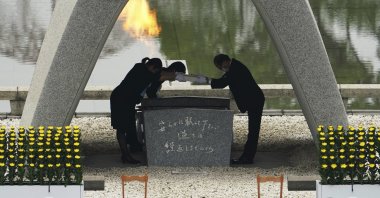 Kazumi Matsui, right, mayor of Hiroshima, and the family of the deceased bow before they place the victims list of the Atomic Bomb at Hiroshima Memorial Cenotaph during the ceremony to mark the 75th anniversary of the bombing at the Hiroshima Peace Memorial Park Thursday, Aug. 6, 2020, in Hiroshima, western Japan. (AP Photo)