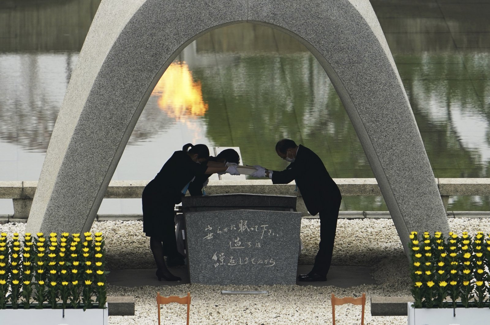 Kazumi Matsui, right, mayor of Hiroshima, and the family of the deceased bow before they place the victims list of the Atomic Bomb at Hiroshima Memorial Cenotaph during the ceremony to mark the 75th anniversary of the bombing at the Hiroshima Peace Memorial Park Thursday, Aug. 6, 2020, in Hiroshima, western Japan. (AP Photo)