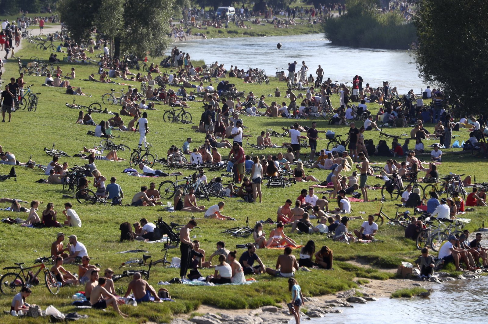 Thousands of people enjoy the summer weather on the banks of the Isar river in Munich, Germany, July 19, 2020. (AP Photo)