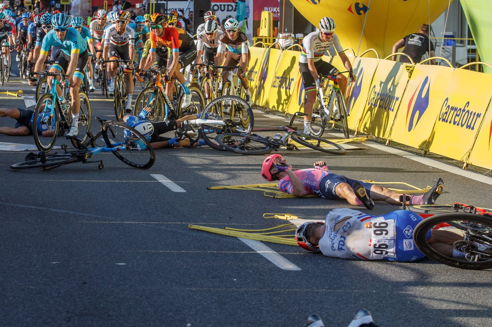 Cyclists lie on the street following a crash in the sprint during the Tour of Poland cycling race, between Chorzow and Katowice, Poland, Aug. 5, 2020. (EPA Photo)