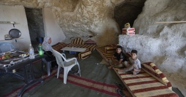Members of a Palestinian family sit inside a cave they use as their home on the outskirts of the West Bank City of Jenin, Palestine, Aug. 1, 2020. (EPA Photo)