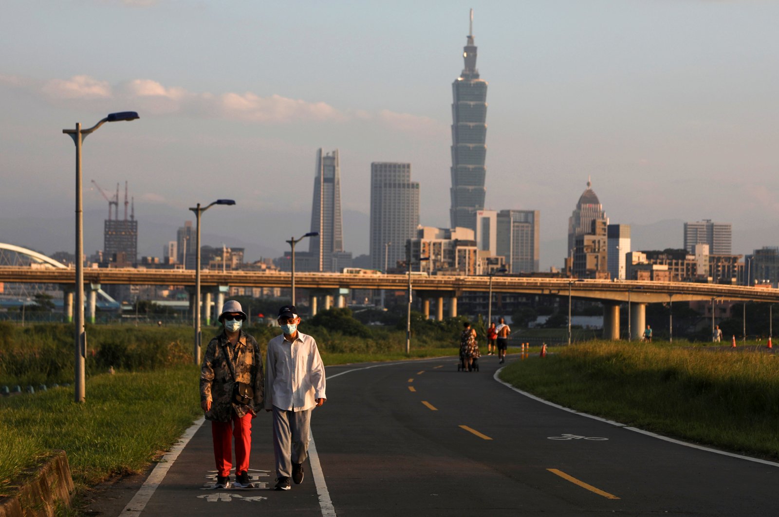 People wear protective masks to prevent the spread of the coronavirus as they walk on a river path at sunset in Taipei, Taiwan, Aug. 6, 2020. (Reuters Photo)