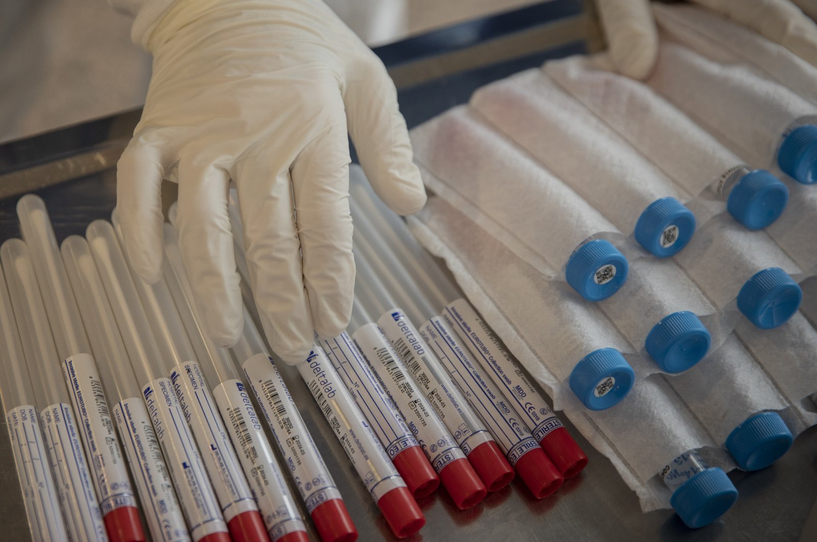 An aid worker from the Spanish NGO Open Arms touches coronavirus detection test kits at a nursing home in Barcelona, Spain on April 1, 2020. (AP Photo)