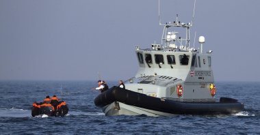 A Border Force vessel assists a group of people thought to be migrants traveling on an inflatable dinghy in the English Channel, Britain, Aug. 10, 2020. (AP Photo)
