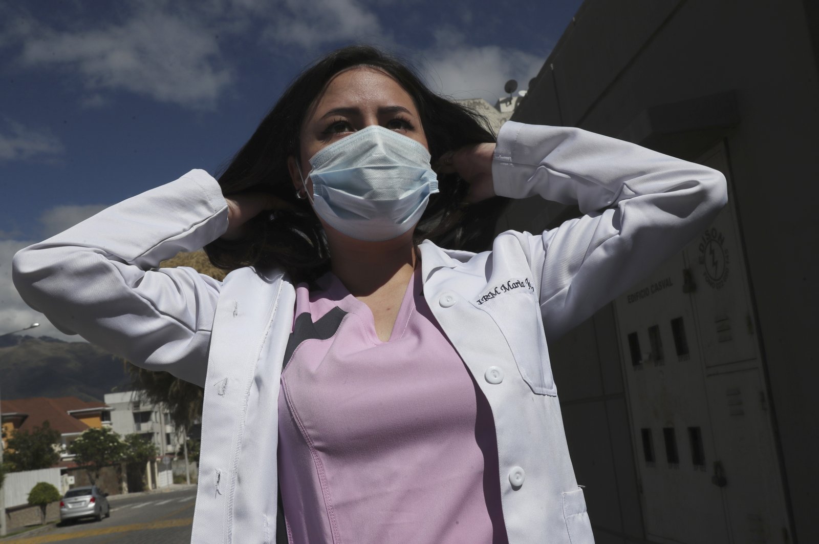 Dr. Maria Jose Casco, 24, adjusts her hair as she walks near her home in Quito, Ecuador, Aug. 5, 2020. A newly qualified doctor, Maria has not found work after graduating in Ecuador in April. (AP Photo)