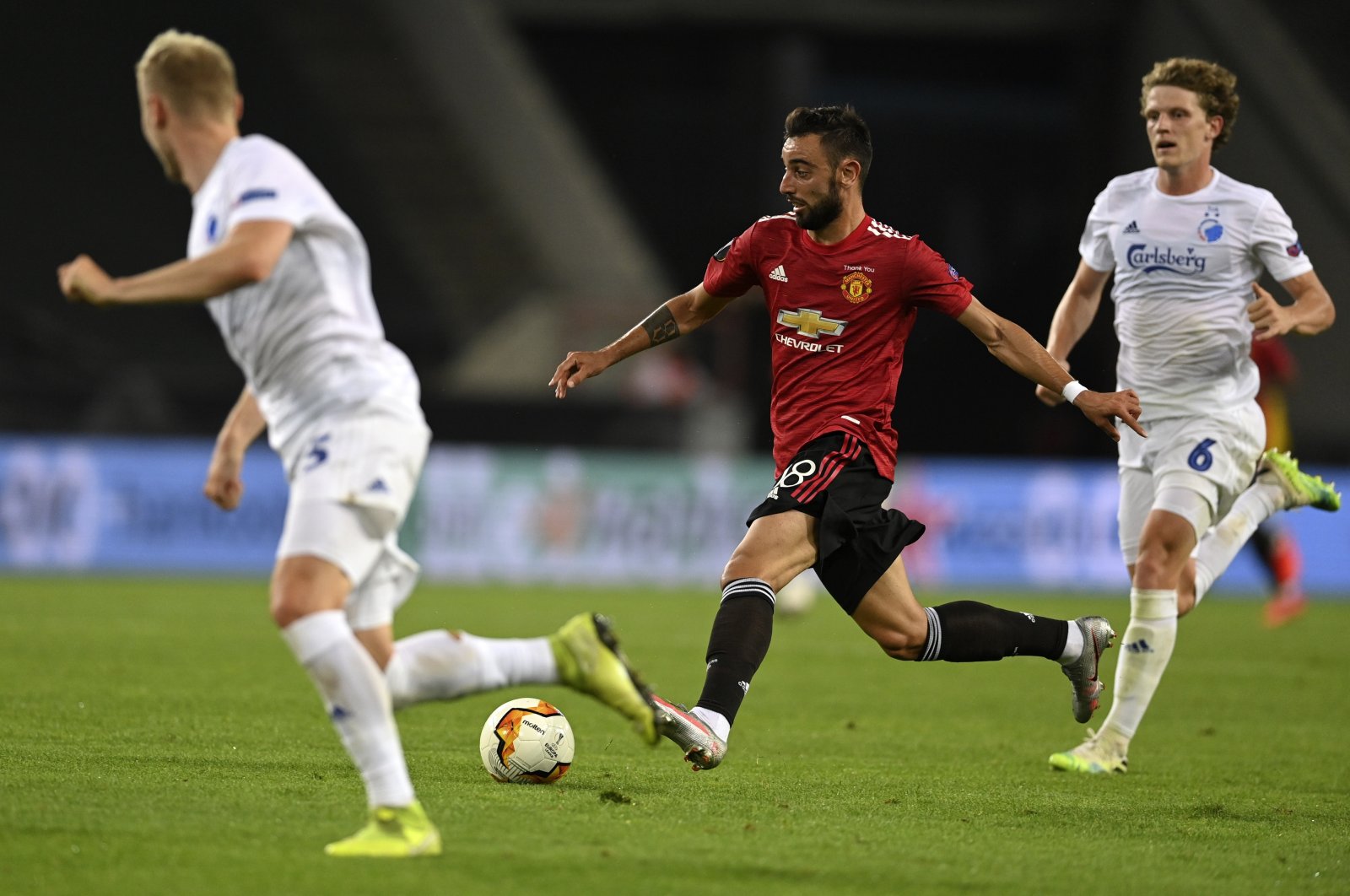 Manchester United's Bruno Fernandes, center, controls the ball during the Europa League quarter-final football match between Manchester United and Copenhagen at the Rhein Energie Stadium in Cologne, Germany, Monday, Aug. 10, 2020. (EPA via AP)