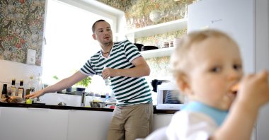 Henrik Holgersson cares for his son, Arvid, in the kitchen of their home in Stockholm, June 29, 2011. (AP Photo)