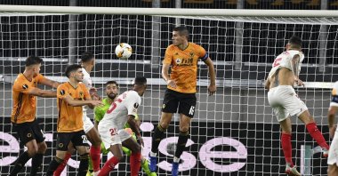 Sevilla's Lucas Ocampos, right, heads the ball to score his team's first goal during the Europa League quarterfinal match against Wolverhampton Wanderers in Duisburg, Germany, Aug. 11, 2020. (AP Photo)