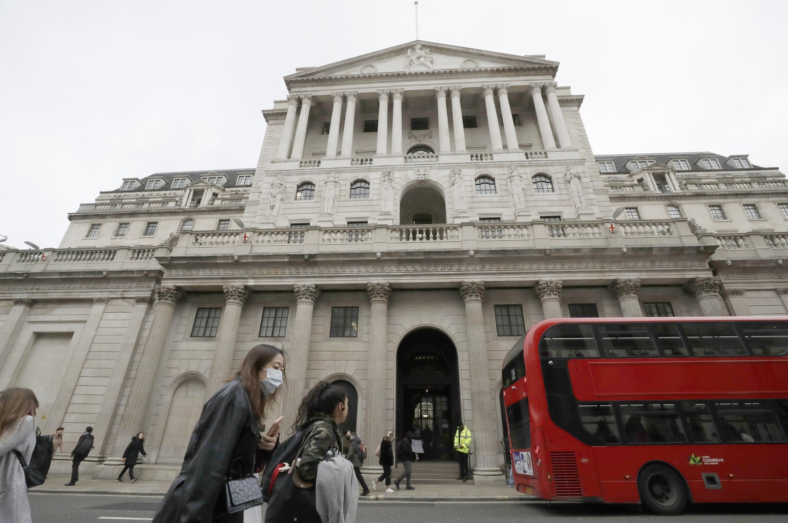 Pedestrians wearing face masks pass the Bank of England in London, Britain, March 11, 2020. (AP Photo)