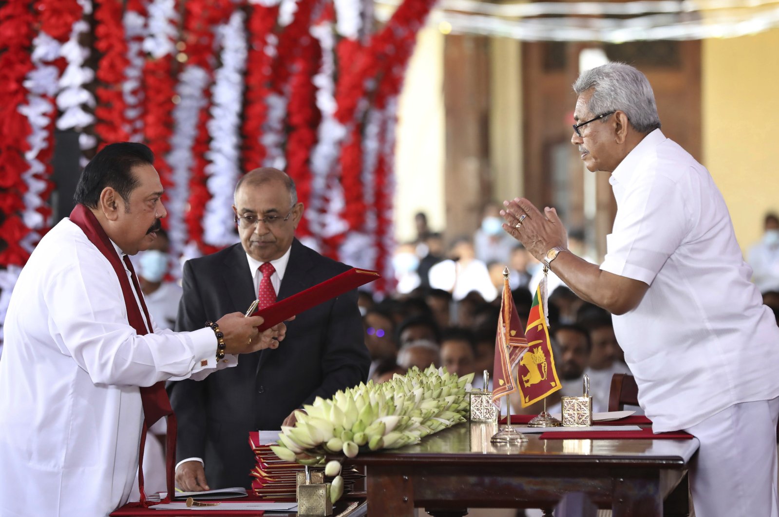 Sri Lankan President Gotabaya Rajapaksa (R) hands over credentials to his elder brother, Prime Minister Mahinda Rajapaksa during a ceremony, Kandy, Aug. 12, 2020. (AP Photo)
