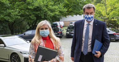 Melanie Huml, Health Minister of the German state of Bavaria, left, and Bavaria's premier Markus Soeder, right, arrive for a joint press conference in Munich, Germany, Thursday, Aug. 13, 2020. (AP Photo)