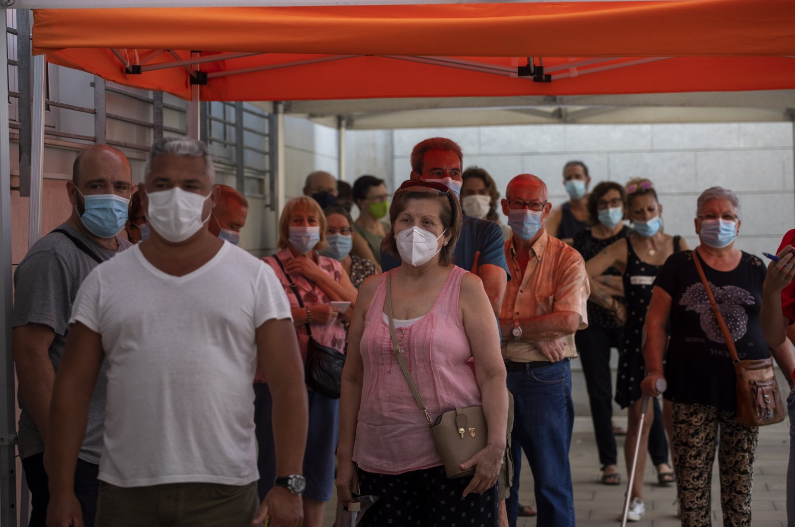 People wearing face masks queue up to be tested for COVID-19, outside a local clinic in Santa Coloma de Gramanet in Barcelona, Spain, Aug. 11, 2020. (AP Photo)