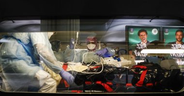 Medical staff place a patient infected with the COVID-19 virus onto a train at the Gare d'Austerlitz train station, Paris, Wednesday, April 1, 2020. (Pool via AP)