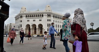 People wearing protective masks walk past the La Grande Poste (main post office) building in the center of the capital Algiers, Algeria, Aug. 12, 2020. (AFP Photo)